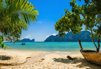 Exotic beach with palms and boats on azure water, Phi Phi Island - obrazy, fototapety, plakaty