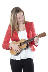Fototapeta premium teenage girl plays ukelele in studio against white background