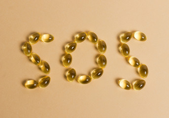 pills forming the word “SOS”