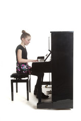 teenage girl plays the piano in studio