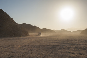 Off road vehicle traveling through arid desert landscape