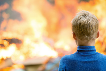 Child boy at burning house fire accident background