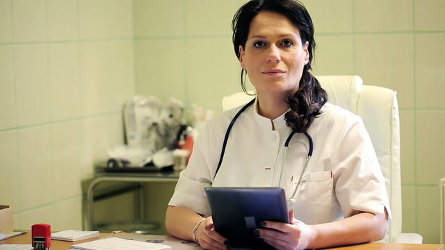 Portrait of happy, smiling female doctor with tablet 
