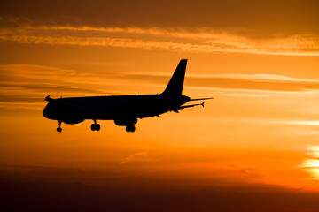 Fototapeta na wymiar Airplane landing at sunset, Frankfurt, Germany
