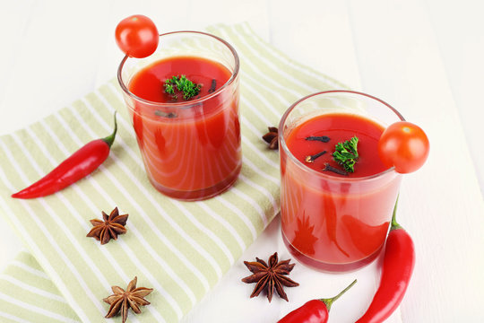 Tomato juice in glasses and fresh vegetables