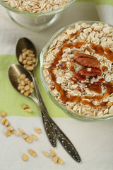 Tasty dessert with oat flakes and honey, on table