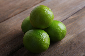 Fresh juicy limes on wooden background
