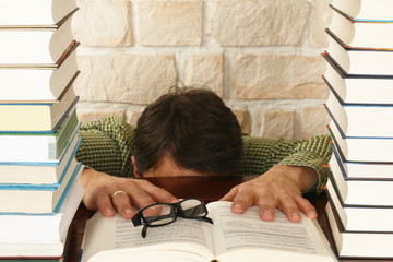 man versteckt sich hinter Tisch, Bücherstapel,lernen