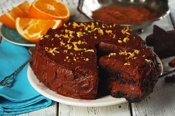 Chocolate cake with chocolate cream on wooden table close-up