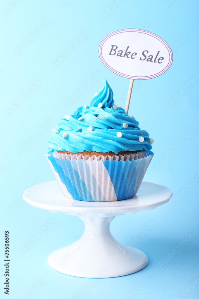 Wall mural Delicious cupcake with inscription on blue background