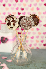 Tasty cake pops and gifts on color background