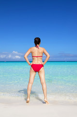 Young asian woman wearing red bikini standing facing the sea