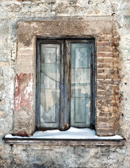 vecchia finestra con vetri rotti e neve sul davanzale