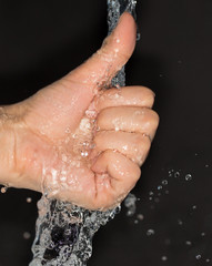 Fototapeta premium hand in water on a black background