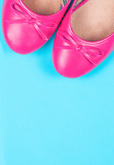 Part of pink shoes on blue background
