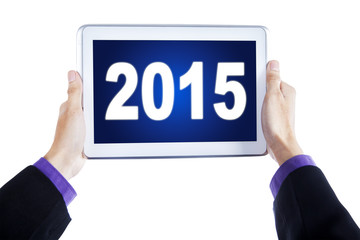 Hands with digital tablet and number 2015