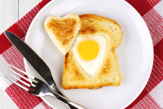 Heart shaped egg in toast for Valentines Day with checked cloth