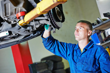 Fototapeta premium auto mechanic at car suspension repairing