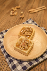 Fototapeta na wymiar Fresh delicious caramel nut tart dessert on wood board
