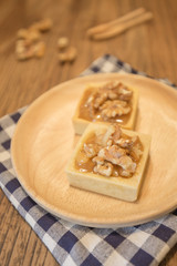 Fresh delicious caramel nut tart dessert on wood board