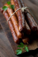 Close-up of smoked sausages on a cutting board, vertical shot