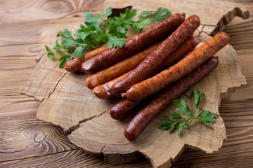 Smoked sausages with fresh parsley over rustic wooden background