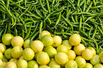 fresh green chili peppers and lemons in asian market