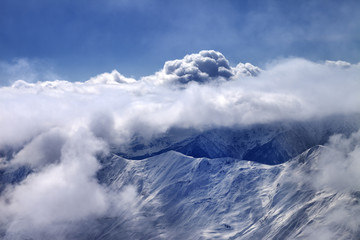 View on off-piste slope at mist and sunlight clouds