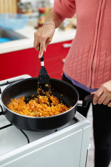 Woman cooking veggies in a pan