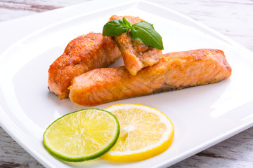 Salmon steak with lemon and lime on the plate
