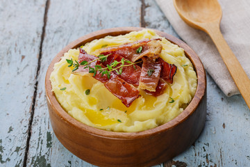 mashed potatoes with bacon in a wooden bowl