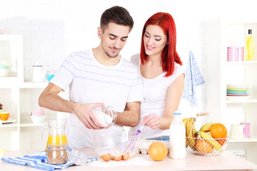 Obraz na płótnie Canvas Happy couple preparing dough baking in kitchen