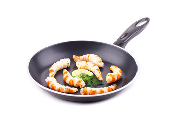 Raw shrimps on pan with lemon.