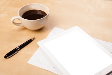 Tablet pc with empty space and a cup of coffee on a desk