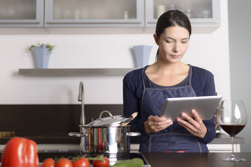 Hausfrau liest ein Rezept auf dem Tablet Computer
