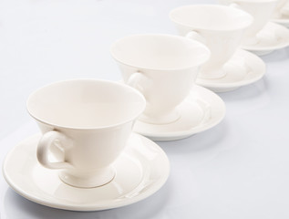 Ceramic saucer and teacup over white background 