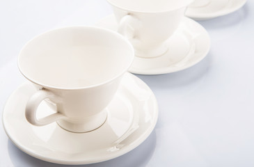 Ceramic saucer and teacup over white background 