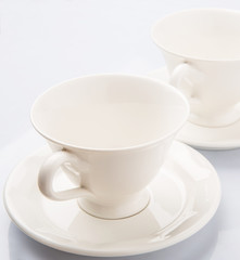 Ceramic saucer and teacup over white background 