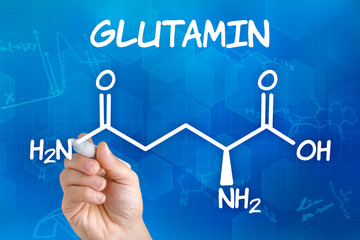 Hand mit Stift zeichnet chemische Strukturformel von Glutamin