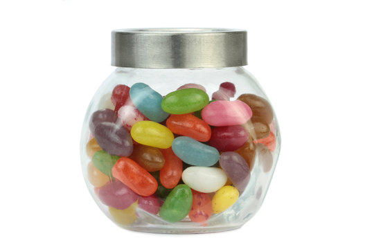 Colorful jelly beans in a jar isolated on white.