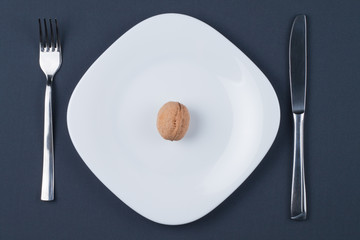 Circassian walnut on white plate with knife and fork