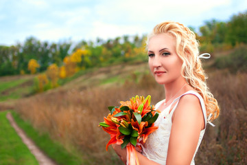 Naklejka premium Beautiful bride posing outdoors with a bouquet
