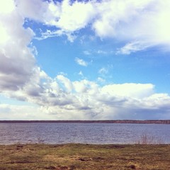 Landscape with lake and blue sky with white clouds