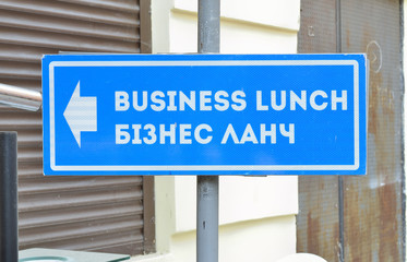 blue guide-board with pointer near cafe