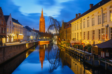 Fototapeta na wymiar Cityscape with canal Dijver and a Church of Our Lady in Bruges a