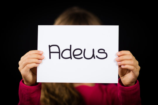 Child holding sign with Portuguese word Adeus - Goodbye