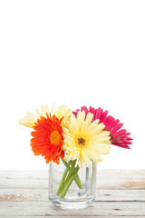 Colorful gerbera flowers on wooden table