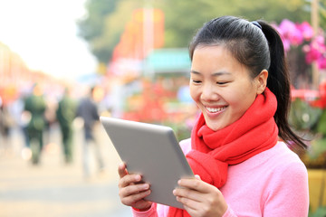 young asian woman use digital tablet on street