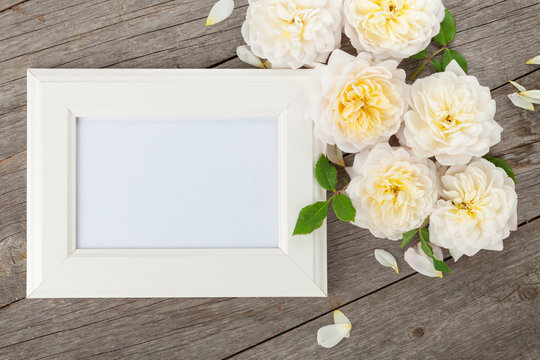 Blank photo frame and white roses