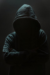 Fototapeta na wymiar Unrecognizable person wearing hood against black background